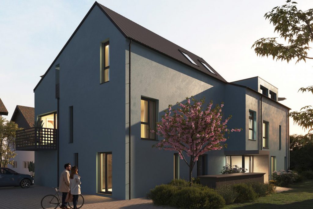 Modernes, zweistöckiges Wohnhaus mit Satteldach und Balkon, umgeben von Garten mit blühendem Baum, zwei Personen vor dem Haus bei Dämmerung.