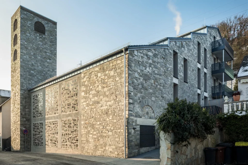 Modernes Gebäude im Rheingau mit grauer Natursteinfassade und hohem Turm an einer Straßenecke